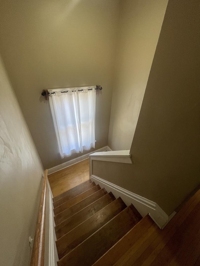 stairs featuring baseboards and wood finished floors