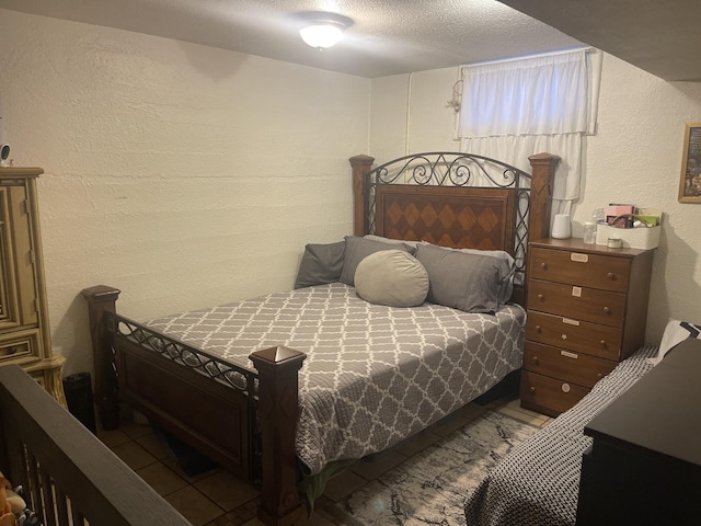 bedroom featuring a textured ceiling and a textured wall