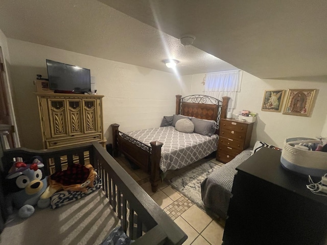 bedroom featuring light tile patterned flooring and a textured ceiling