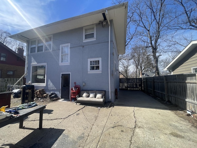 back of property featuring stucco siding and fence