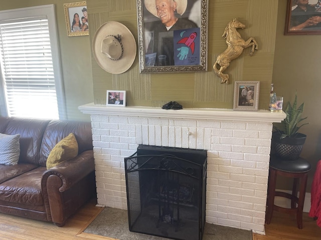 details featuring a brick fireplace and wood finished floors