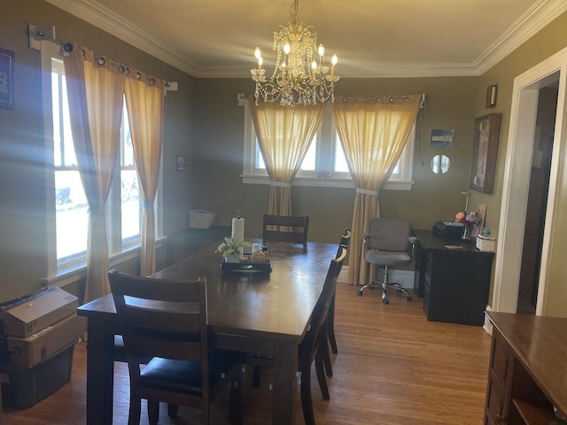 dining room with crown molding, wood finished floors, and a chandelier