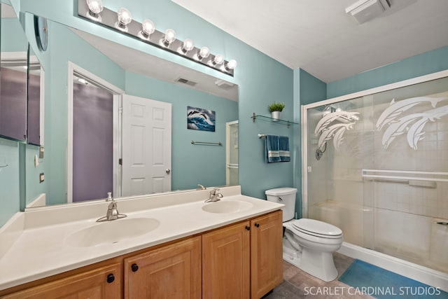 bathroom with a stall shower, toilet, visible vents, and a sink