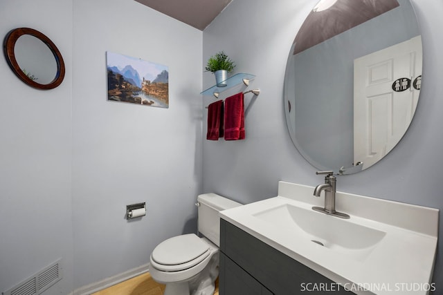 bathroom featuring visible vents, toilet, and vanity