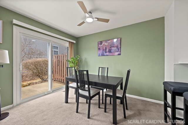 carpeted dining space with baseboards and ceiling fan