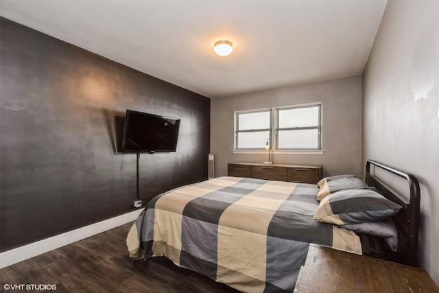 bedroom with baseboards and wood finished floors