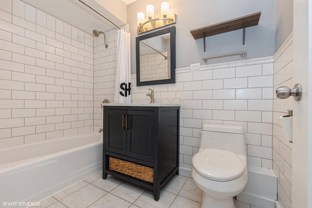 full bath featuring tile walls, toilet, shower / bath combo with shower curtain, wainscoting, and vanity