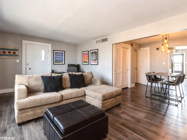 living area with visible vents, baseboards, and dark wood-type flooring