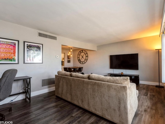 living room with dark wood-style floors, visible vents, and baseboards