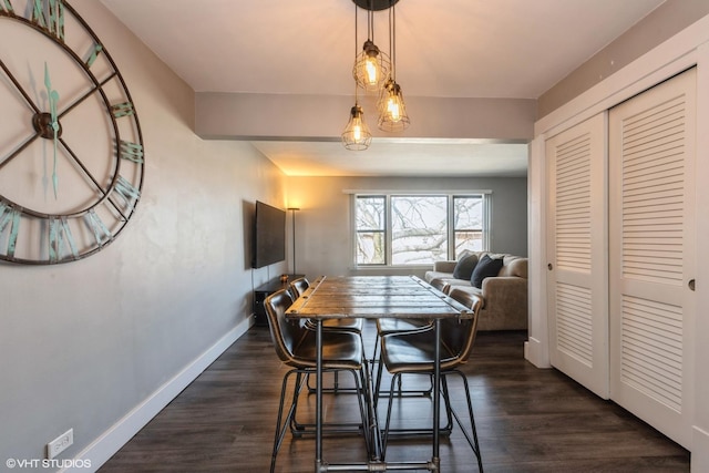 dining space featuring dark wood-type flooring and baseboards