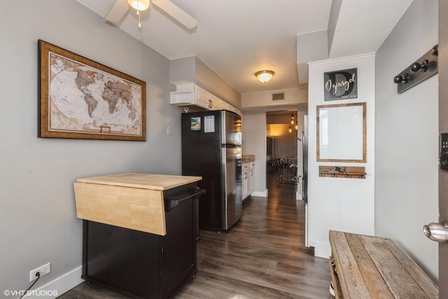 kitchen featuring a ceiling fan, dark wood-style floors, visible vents, baseboards, and freestanding refrigerator