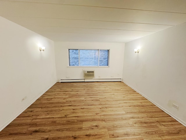 empty room with wood finished floors and a wall mounted air conditioner