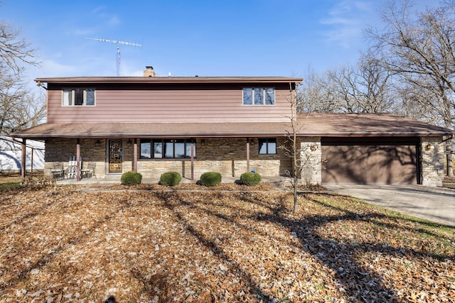 view of front of house with driveway, stone siding, covered porch, a garage, and a chimney