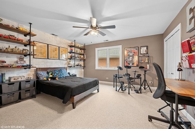 carpeted bedroom featuring visible vents, brick wall, baseboards, a closet, and a ceiling fan