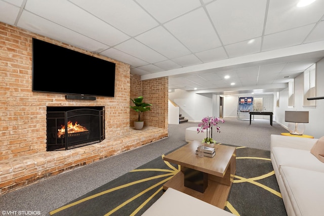 living room with a drop ceiling, stairway, carpet, and a fireplace