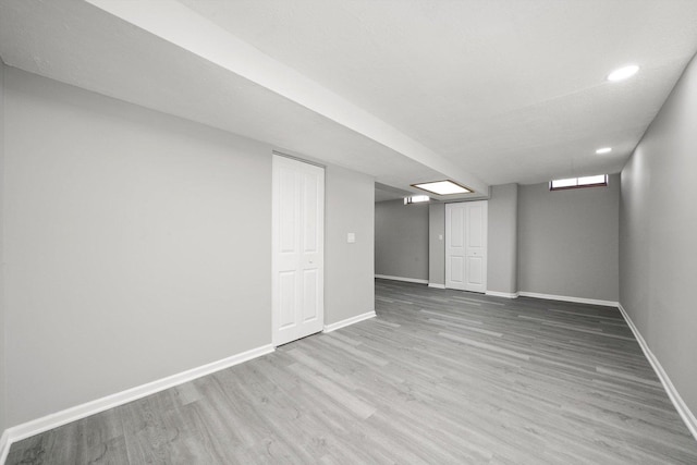 basement featuring recessed lighting, baseboards, and wood finished floors