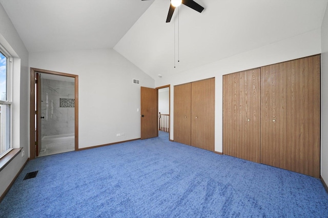 unfurnished bedroom with visible vents, two closets, carpet flooring, and vaulted ceiling