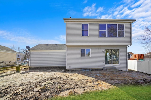 rear view of house with entry steps, a patio area, and fence