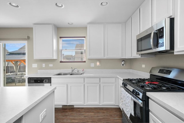 kitchen featuring a sink, appliances with stainless steel finishes, white cabinets, and light countertops