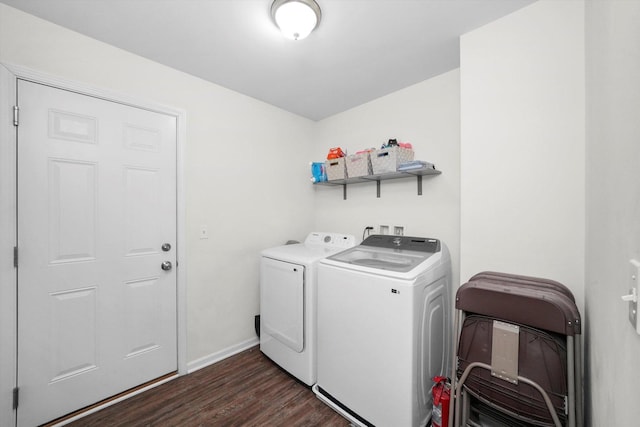 laundry area with dark wood finished floors, laundry area, washing machine and dryer, and baseboards