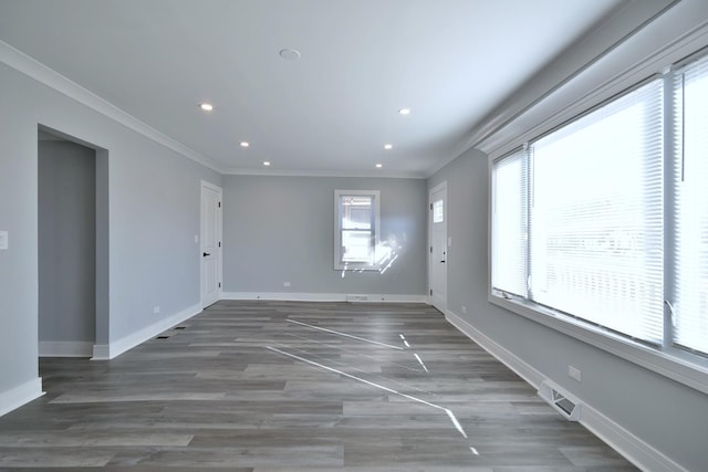 unfurnished room featuring visible vents, ornamental molding, wood finished floors, recessed lighting, and baseboards