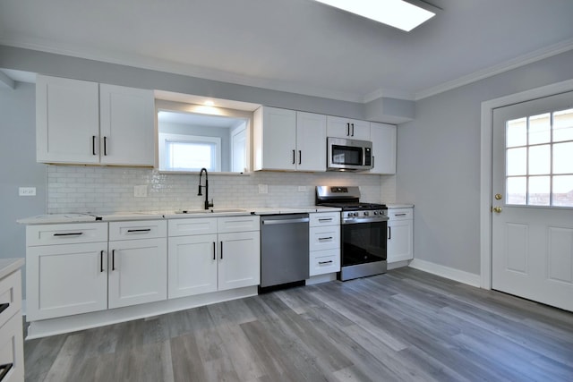 kitchen with a sink, light countertops, white cabinets, and stainless steel appliances