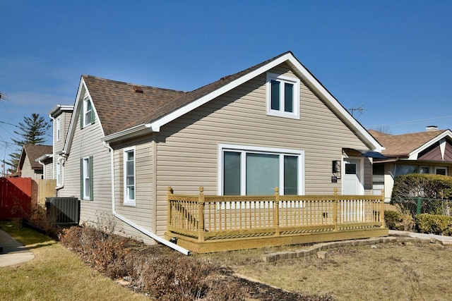 back of house with cooling unit, fence, a deck, and roof with shingles