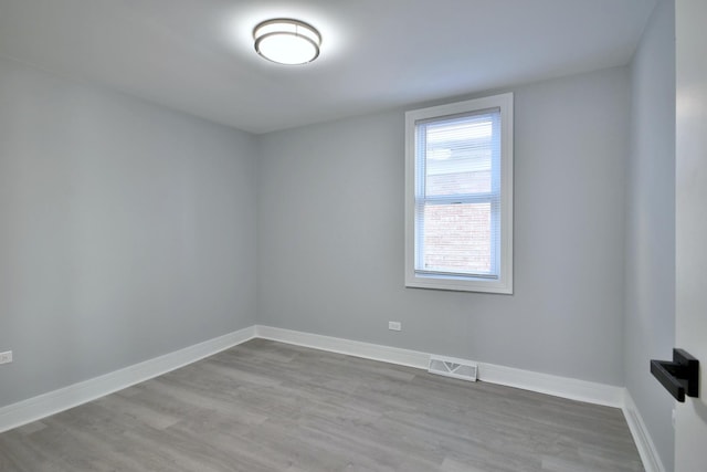 unfurnished room with visible vents, baseboards, and wood finished floors