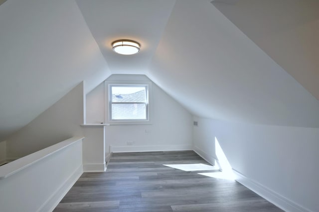 additional living space featuring lofted ceiling, wood finished floors, and baseboards