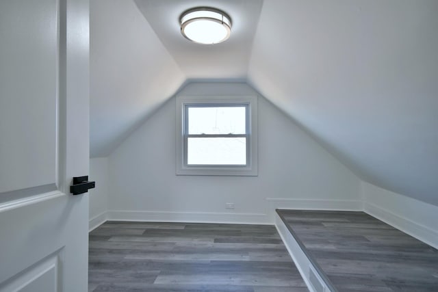 additional living space featuring vaulted ceiling, wood finished floors, and baseboards