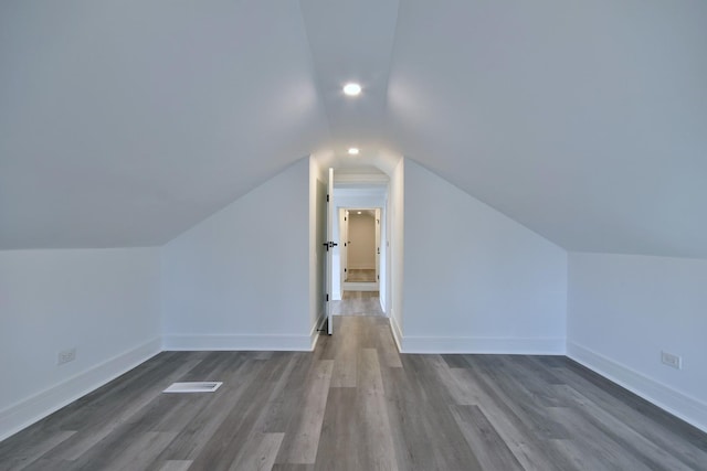 bonus room featuring lofted ceiling, dark wood-style floors, and baseboards