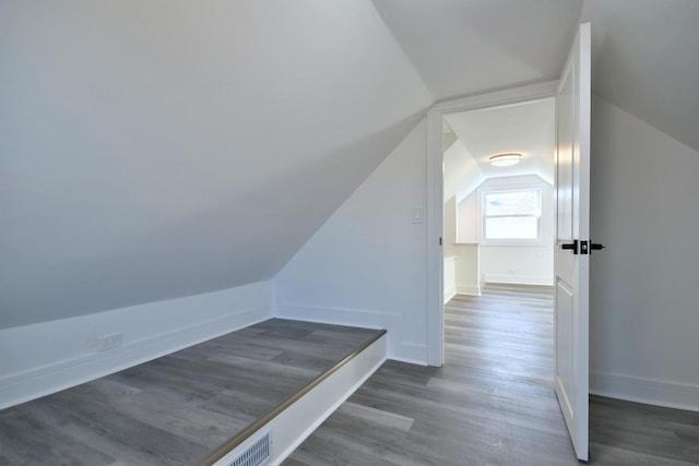 bonus room with baseboards, lofted ceiling, and wood finished floors