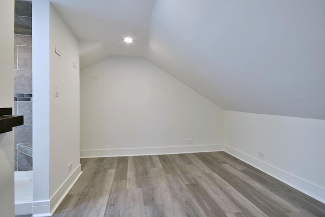 bonus room with baseboards, lofted ceiling, and wood finished floors