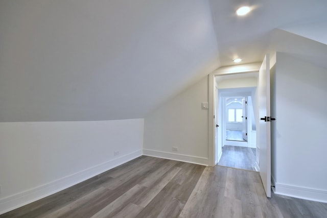 additional living space with lofted ceiling, baseboards, and wood finished floors