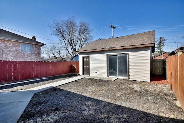 back of house featuring roof with shingles and a fenced backyard