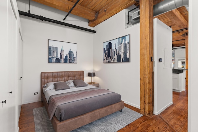 bedroom featuring baseboards, beam ceiling, wood ceiling, and wood finished floors