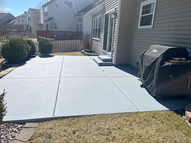 view of patio featuring grilling area, a residential view, and fence