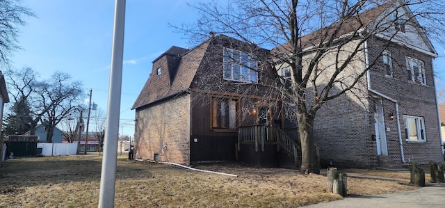 view of home's exterior featuring fence and brick siding