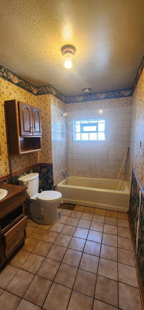 245 153rd Pl, Calumet City, IL 60409 - bathroom with tile patterned flooring, toilet, shower / washtub combination, and wallpapered walls