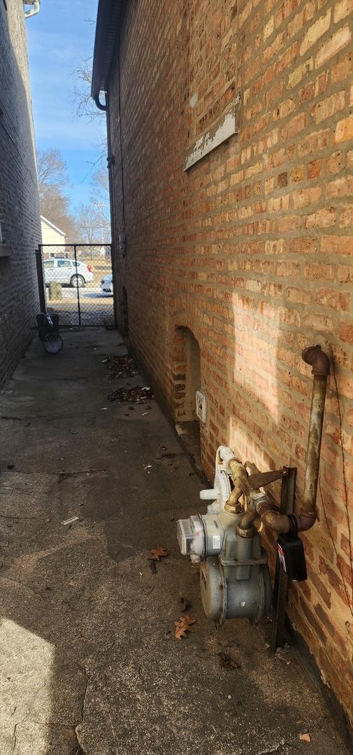 245 153rd Pl, Calumet City, IL 60409 - view of side of home with brick siding and a gate
