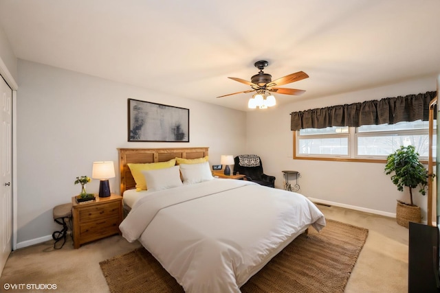 bedroom featuring light carpet, a closet, and baseboards