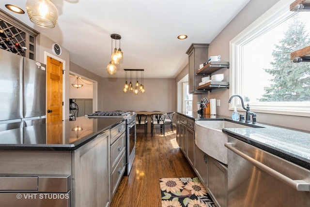 kitchen with dark wood-style floors, hanging light fixtures, stainless steel appliances, and open shelves