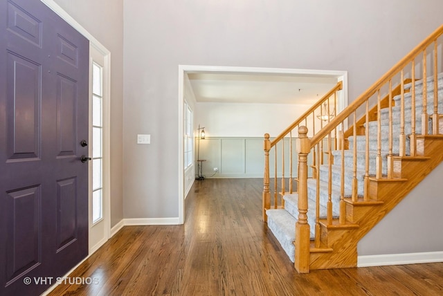 foyer with stairway, baseboards, and wood finished floors