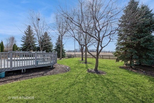 view of property's community featuring a yard, a wooden deck, and fence