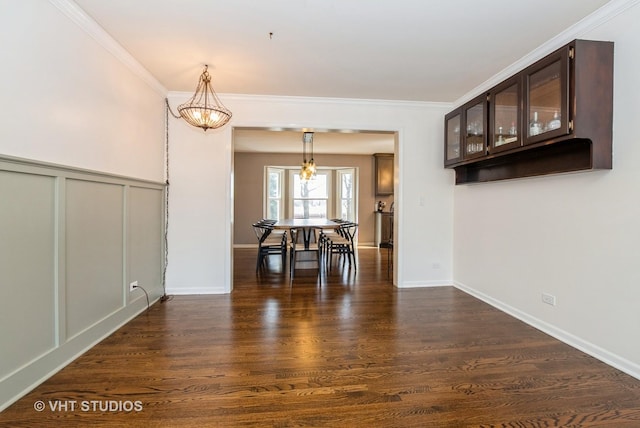 unfurnished dining area featuring a decorative wall, dark wood-style floors, and ornamental molding