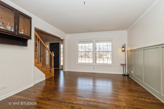 unfurnished living room with stairway, crown molding, baseboards, and dark wood-style flooring