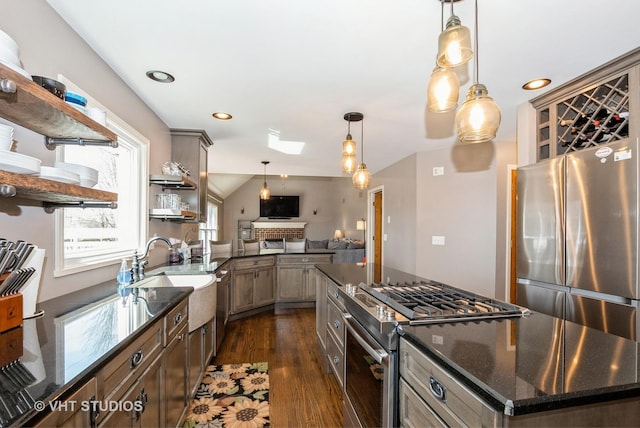 kitchen with dark stone countertops, open shelves, dark wood-type flooring, appliances with stainless steel finishes, and decorative light fixtures