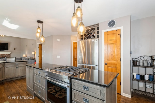 kitchen with a kitchen island, open floor plan, pendant lighting, appliances with stainless steel finishes, and dark wood-style flooring