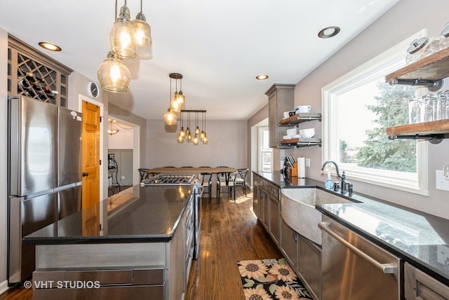 kitchen with a sink, plenty of natural light, appliances with stainless steel finishes, and open shelves