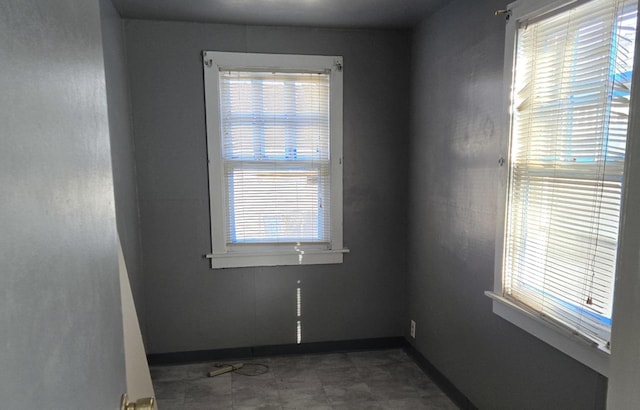 spare room featuring baseboards and a healthy amount of sunlight